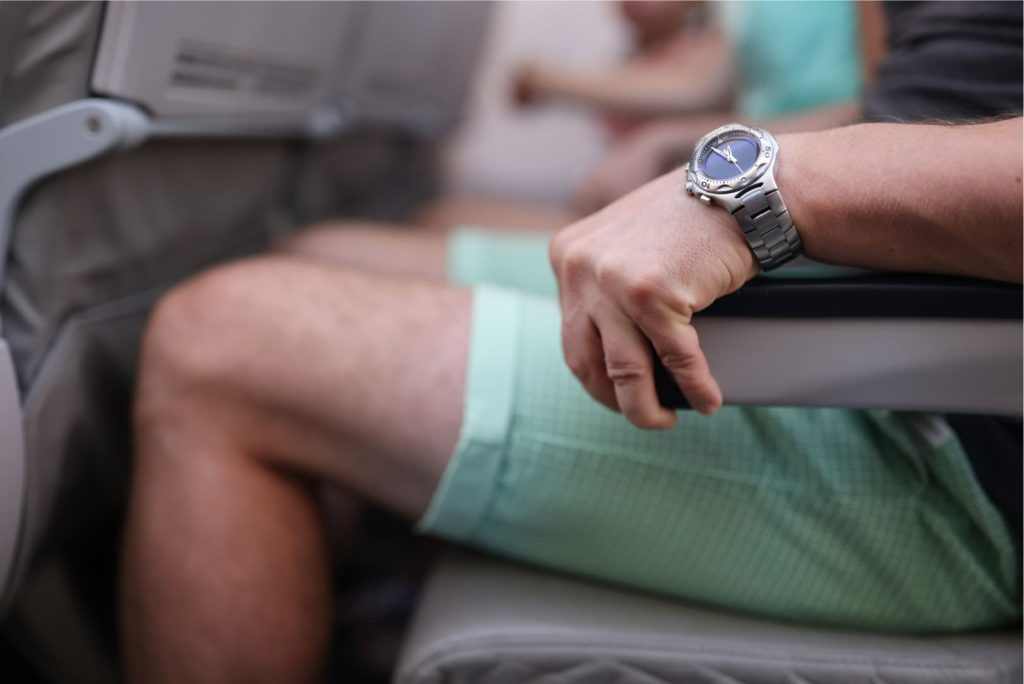 Hand, die im Flugzeug angespannt die Armlehne umklammert