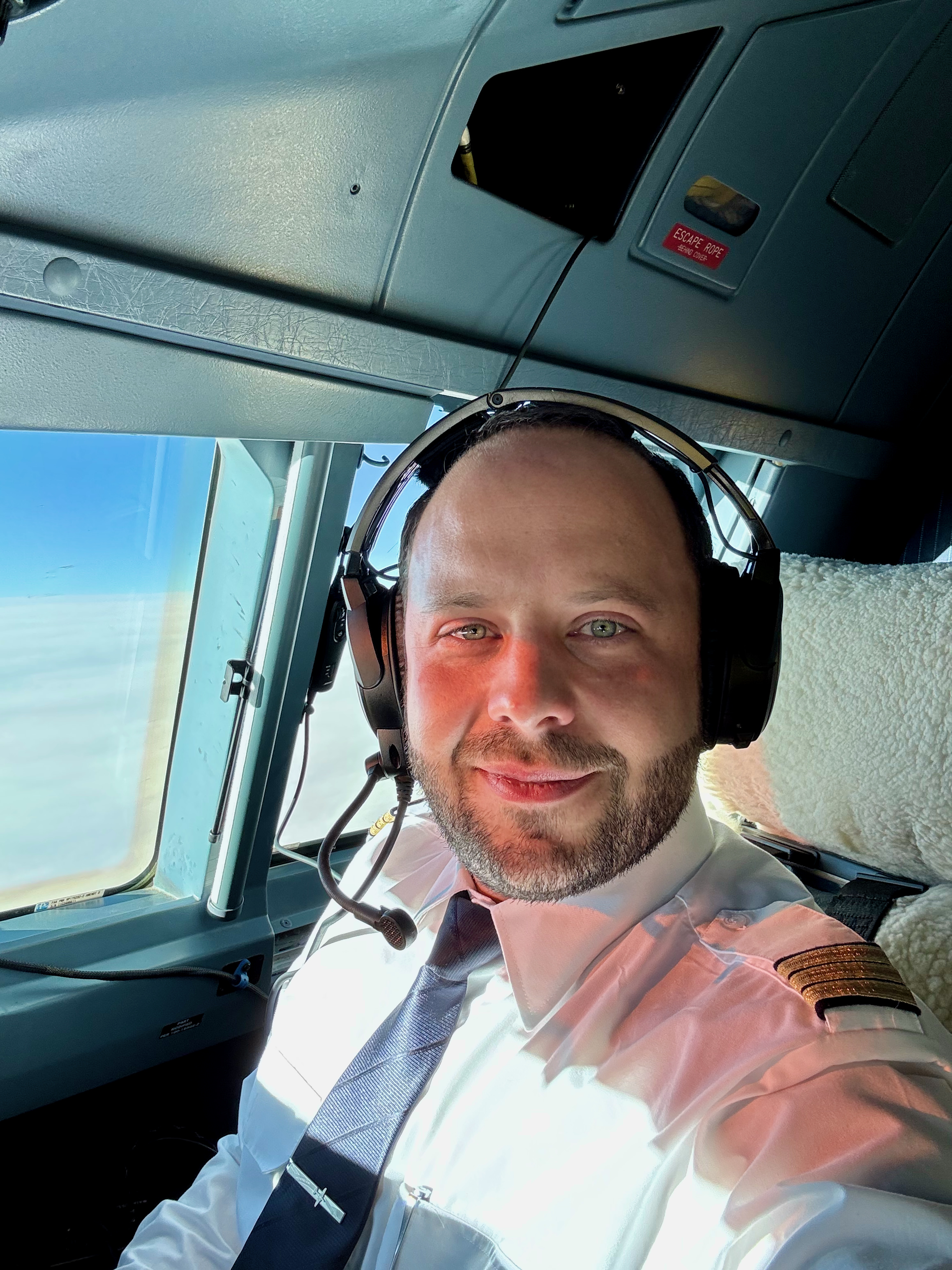 Julian Besken mit Headset im Cockpit während des Flugs