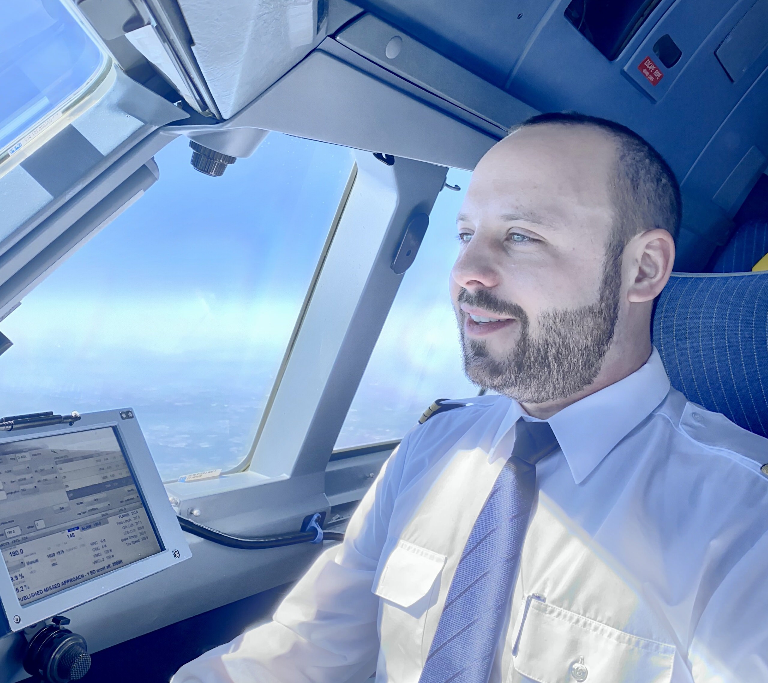 Julian Besken in Uniform im Cockpit, Blick nach vorn aus dem Fenster